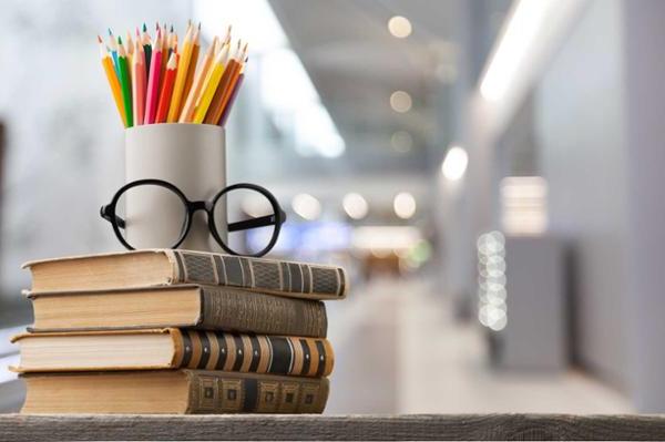 书、眼镜和彩色铅笔堆在桌子上